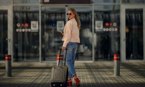 Mujer con maleta en puerta estación