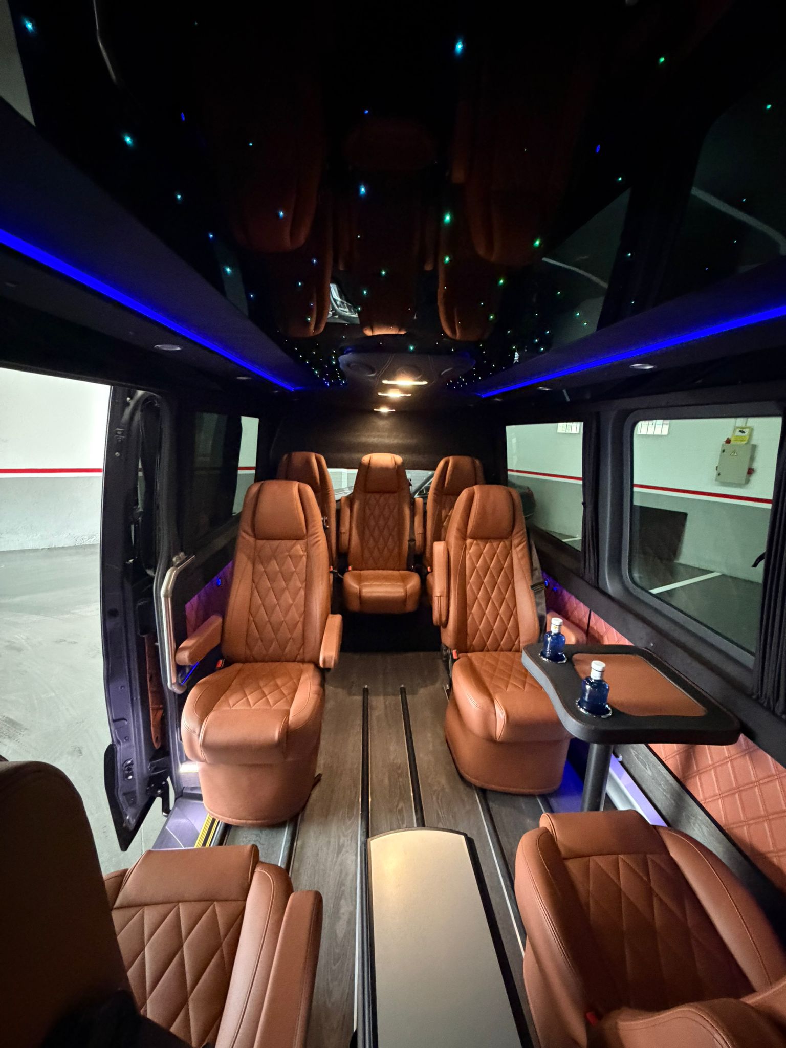 Interior de lujo del Mercedes Sprinter VIP con asientos de cuero cognac y techo estrellado